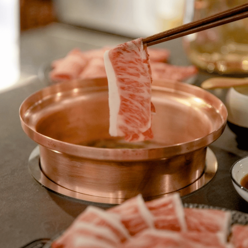 しゃぶ信玄日式個人鍋特寫,高級銅鍋中盛裝澄澈清甜的高湯,正準備涮煮高品質牛肉片,台北信義區推薦火鍋美食