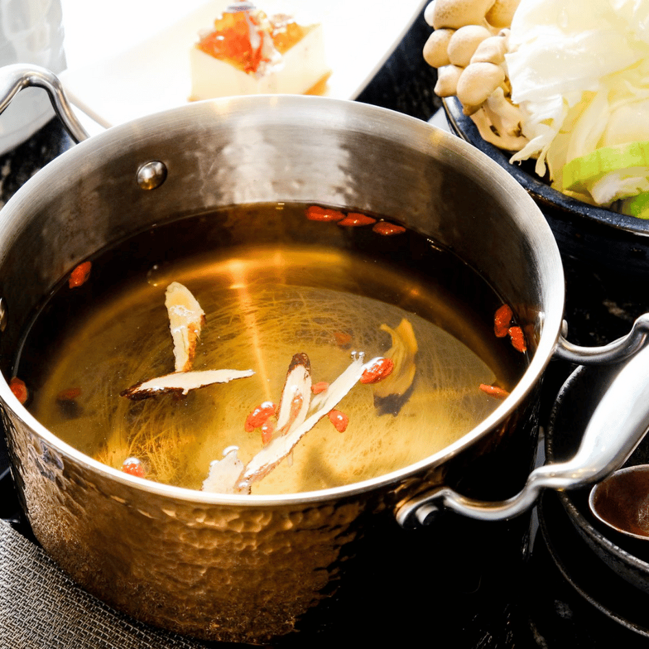 二本松涮涮屋經典火鍋湯底,金黃澄澈的高湯加入中藥材與枸杞慢火熬煮,呈現天然甘甜的健康火鍋風味