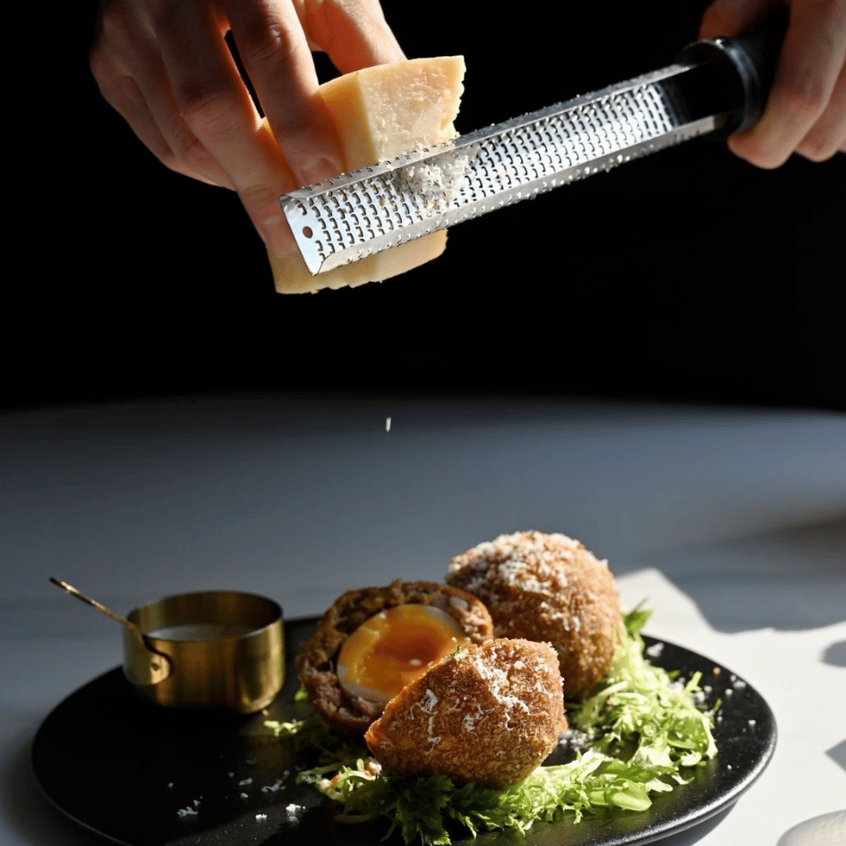 ADDICT 沉癮餐酒館職人現刨起司製作蘇格蘭蛋料理,半熟蛋黃流溢搭配新鮮生菜,展現餐點現做的新鮮度與精緻擺盤