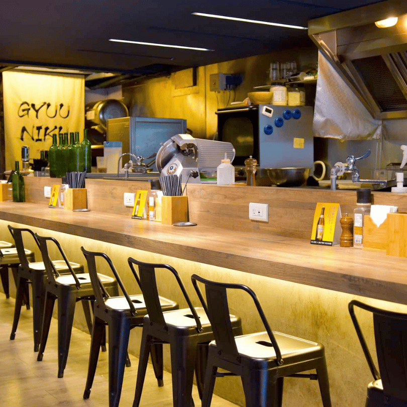 台北永春站 GYUU NIKU ステーキ專門店店內環境,日式木質吧檯座位搭配開放式廚房,營造溫馨且具質感的日式職人用餐氛圍