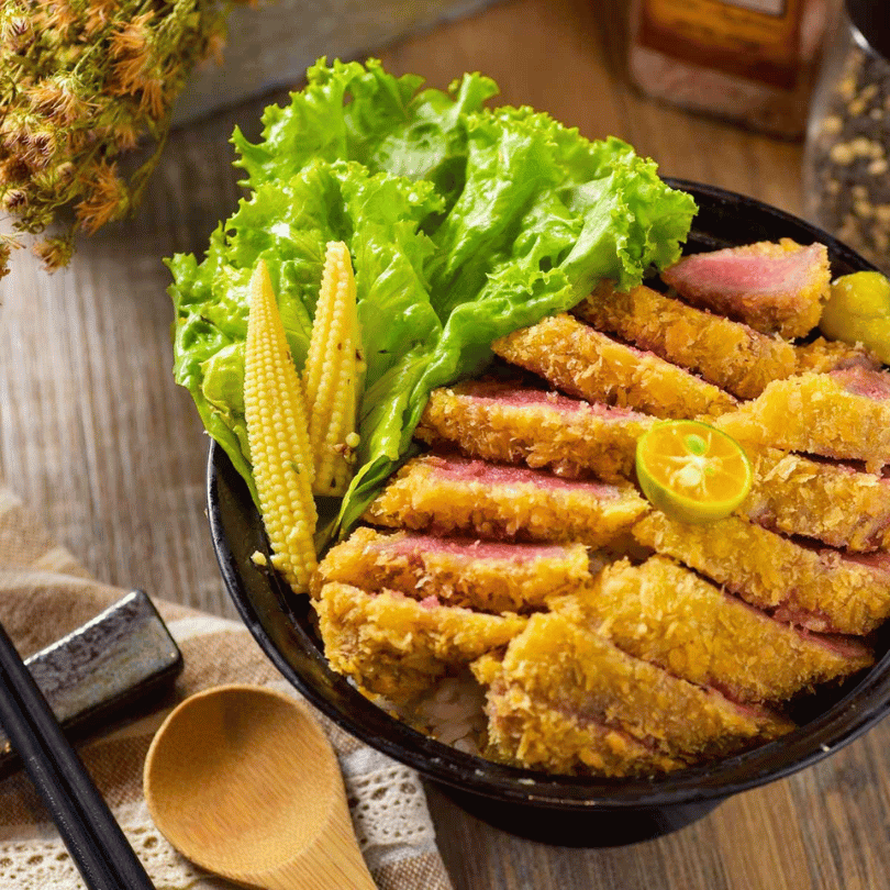GYUU NIKU ステーキ專門店招牌炸牛排丼飯,外皮金黃酥脆內裡呈現粉嫩色澤的炸牛排,搭配新鮮生菜與玉米筍,信義區超人氣炸牛排首選