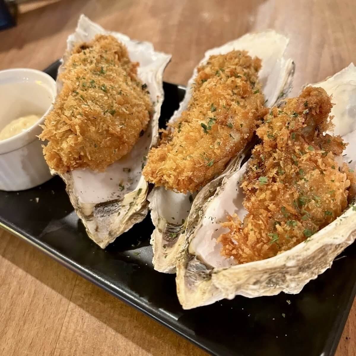 TOKYO KAKI STAND 澀谷道玄坂本店嚴選特大尺寸牡蠣，透過職人精準控制油溫，完美打造出外層乾爽酥脆、內裡鮮嫩噴汁的絕佳狀態。